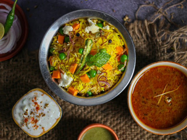 Indian home style vegetable rice with curry and raita served as a simple comfort food meal